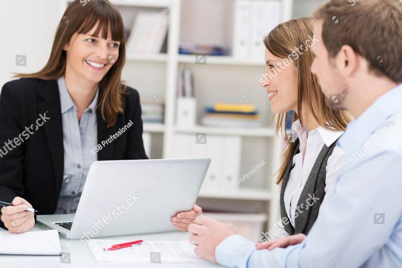 Young couple sitting in an office talking to a woman broker or investment adviser